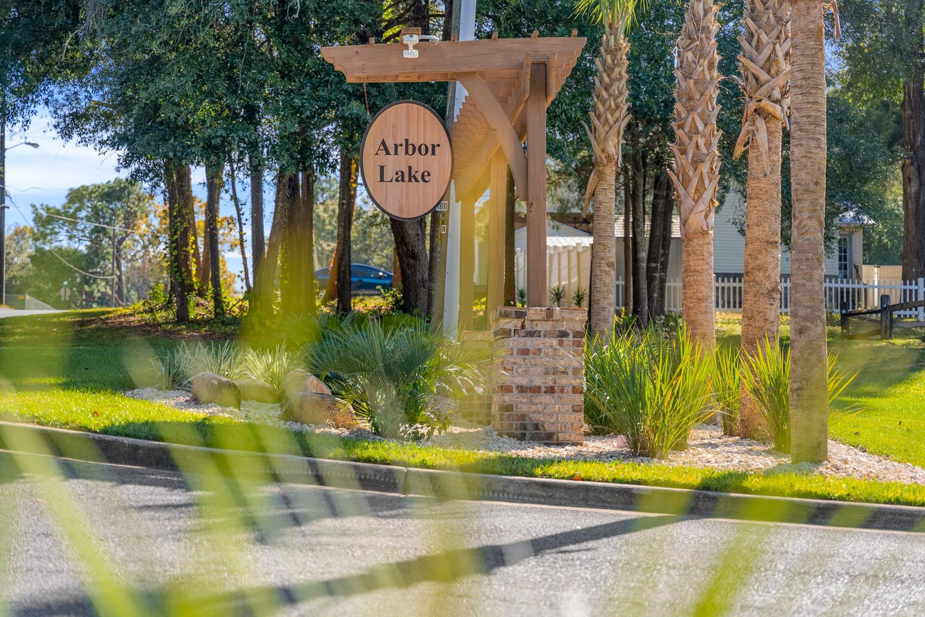 Landscaped Arbor Lake entrance sign with palms